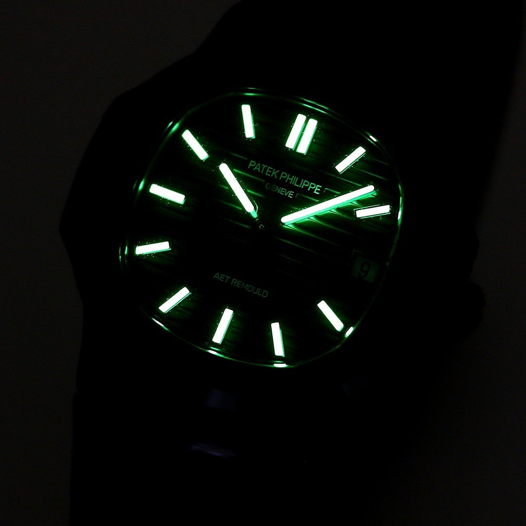 Black dial watch with luminous green hands and indexes in low light