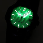 Black wristwatch with bright green luminous dial and raised hour markers in the dark.