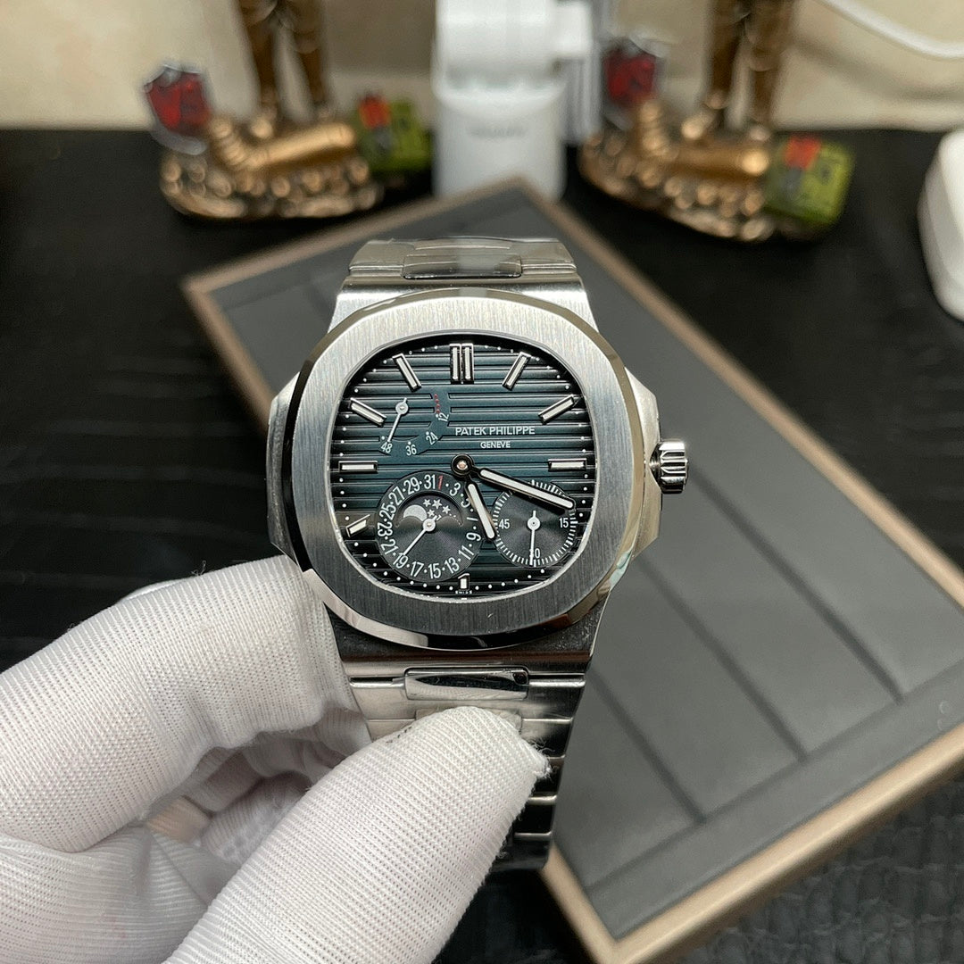 Stainless steel wristwatch with dark dial, teal accents, and linked metal bracelet