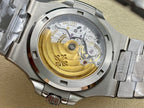Patek Philippe watch movement close-up with gold-toned rotor and brushed steel case