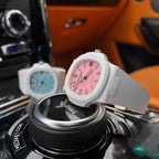 White sport watch with pink dial and silicone strap on a black display stand