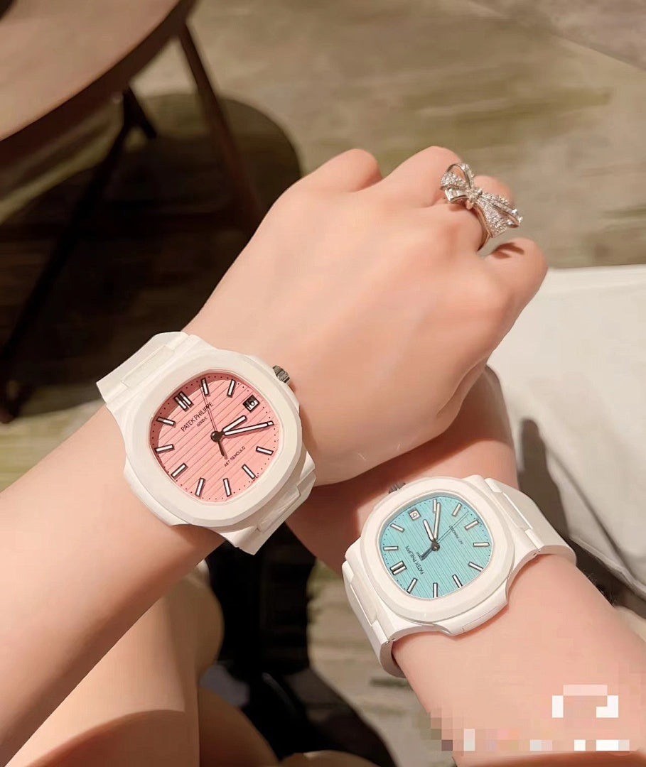 White sport watch with pink dial and silicone strap on wrist, paired with light blue-dial watch