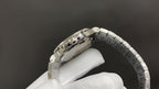 Stainless steel wristwatch side view with crown and textured bracelet links.