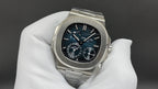 Stainless steel wristwatch with black dial, polished bezel, and multiple subdials.