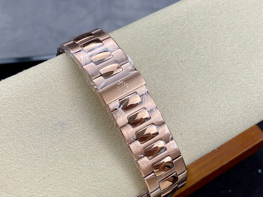 Rose gold-tone metal watch bracelet with interlocking links, side view.
