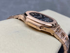 Rose gold-tone watch case side with crown and blue dial window, angled view.