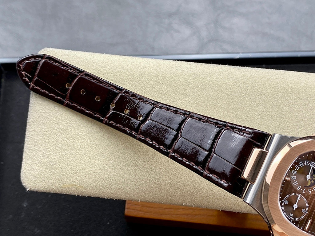 Patek Philippe watch strap close-up: dark brown leather with rose-gold buckle