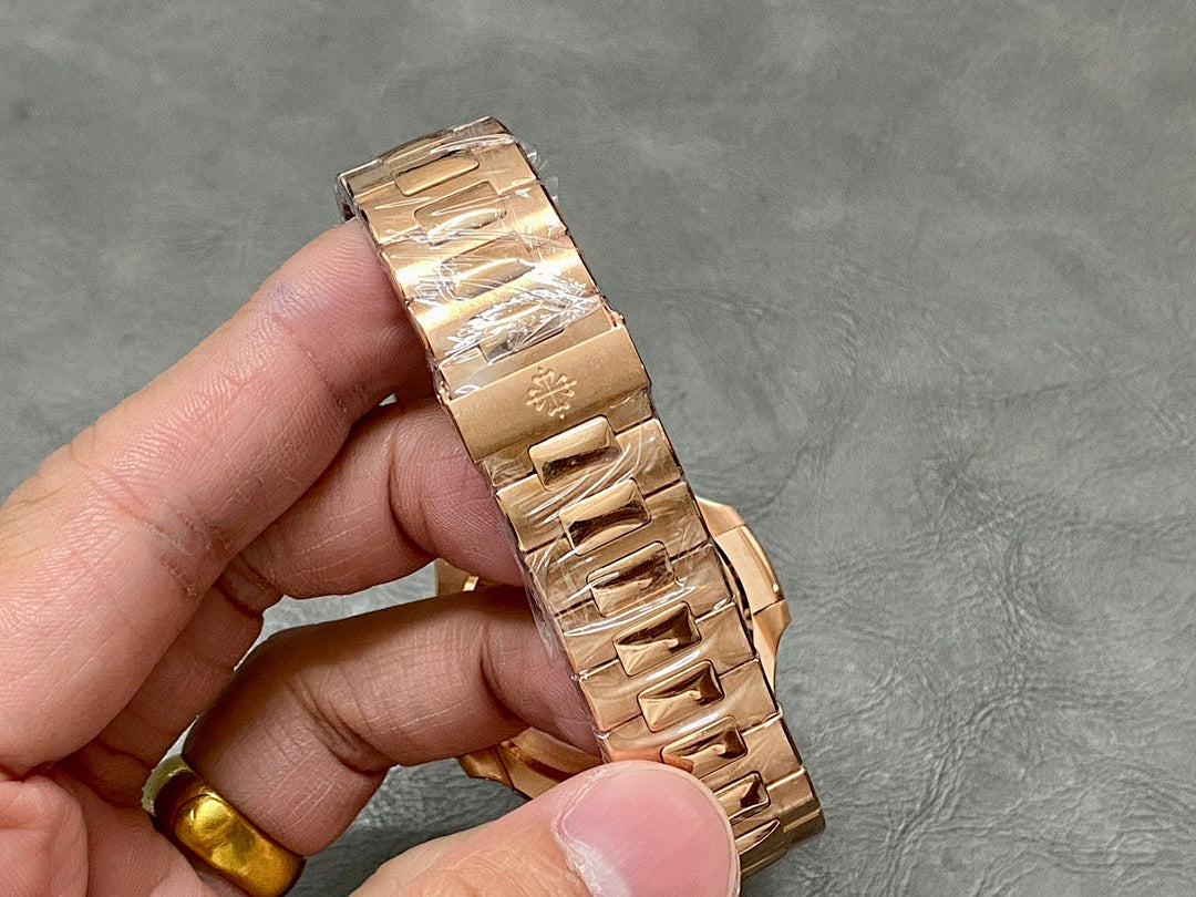 Gold-tone Patek Philippe watch bracelet detail with clasp and folded links.