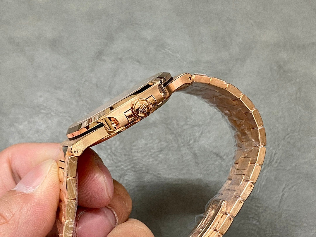 Gold-tone Patek Philippe watch with clasp and side profile, held in hand.