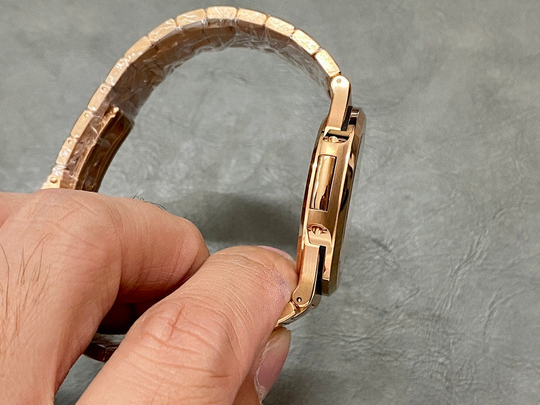 Gold-tone Patek Philippe watch bracelet held upright with clasp at right.