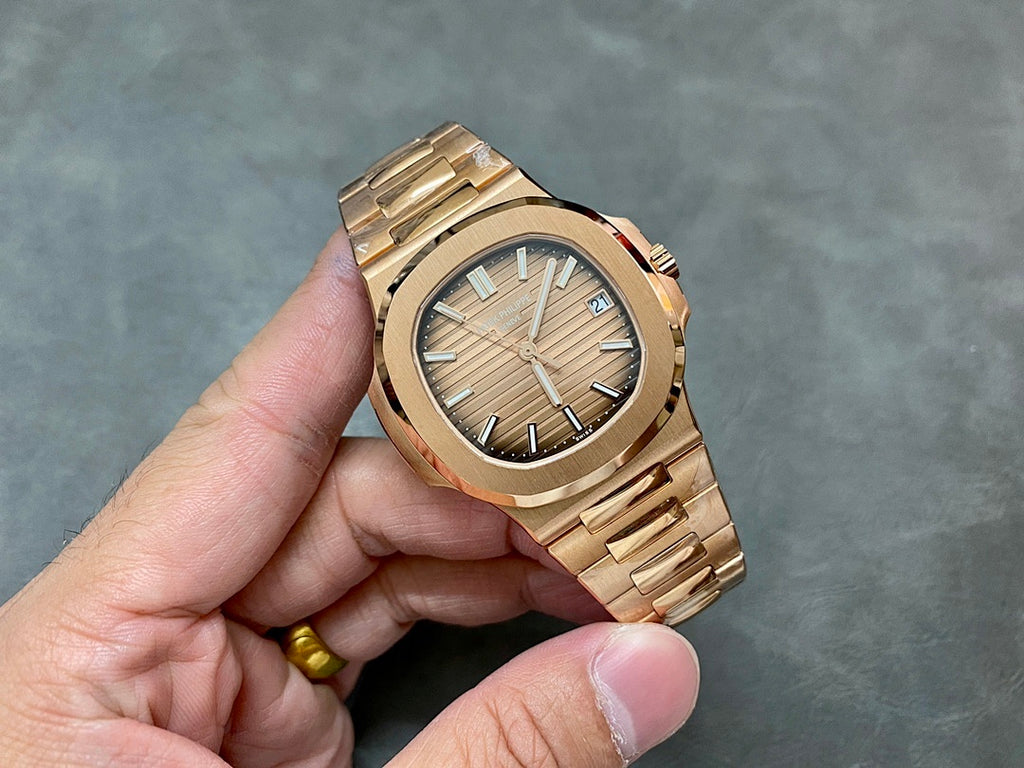 Gold-tone Patek Philippe wristwatch with textured champagne dial and metal bracelet.