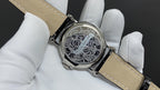 Patek Philippe watch with ornate engraved case back, tan leather strap