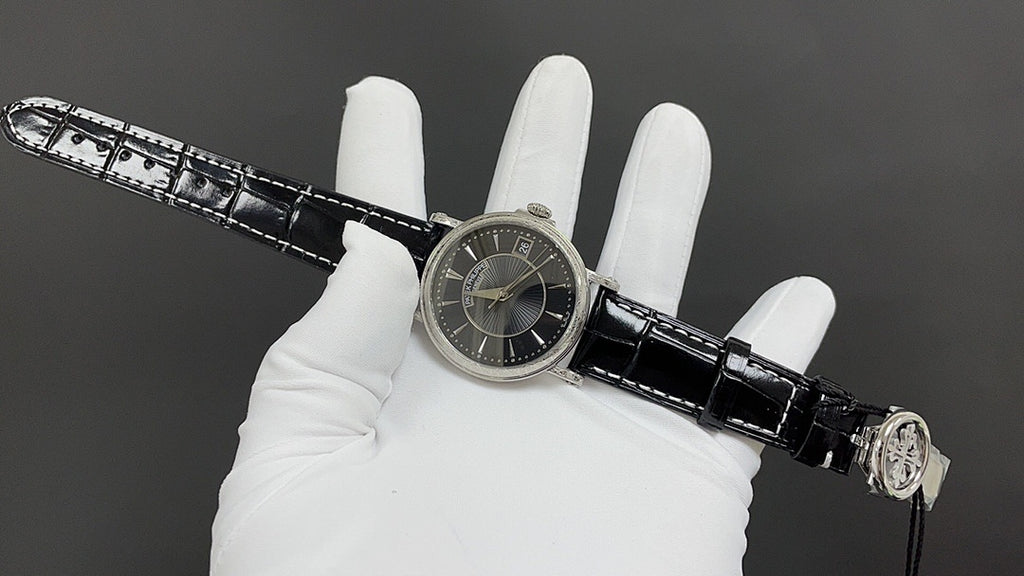 Patek Philippe wristwatch on black leather strap, side view of black dial