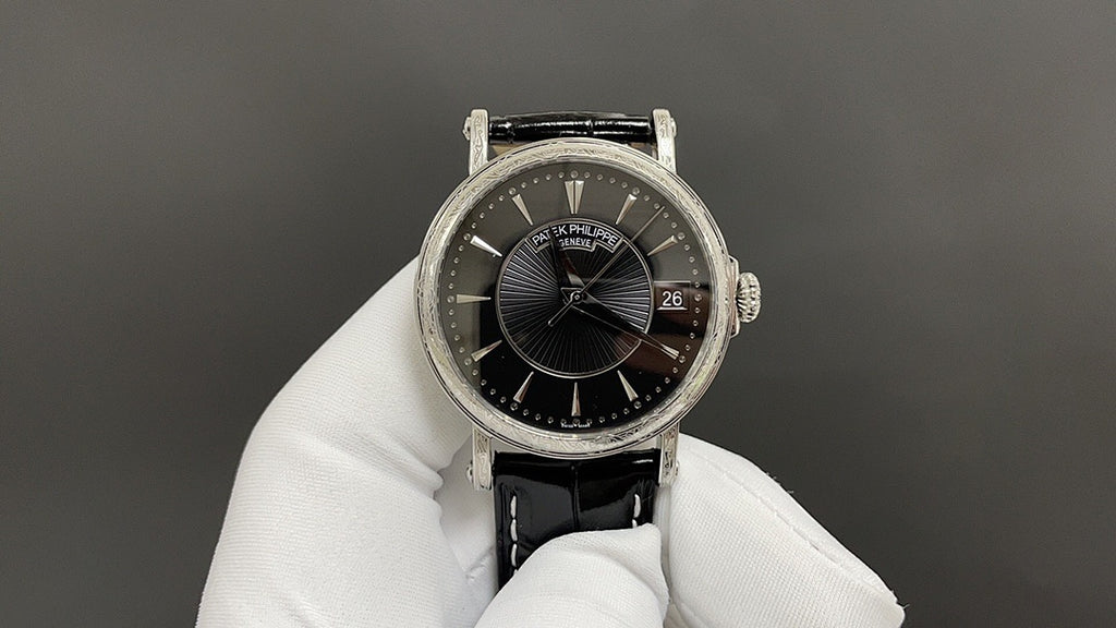 Patek Philippe wristwatch with black dial and date, silver case, black leather strap
