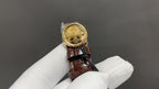 Patek Philippe watch crown view with brown leather strap and round gold caseback