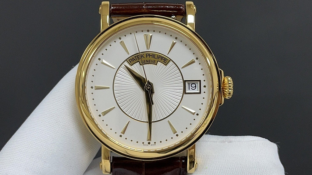 Patek Philippe watch front view with gold case, white dial and brown leather strap