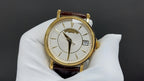 Patek Philippe watch front view with gold bezel, white dial and brown leather strap