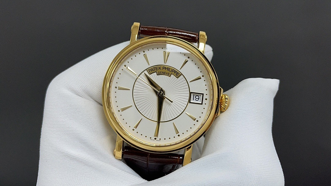 Patek Philippe watch front view with gold bezel, white dial and brown leather strap