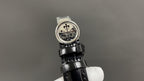 Wristwatch caseback with decorative medallion, black leather strap