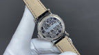 Wristwatch with ornate silver caseback, tan leather strap