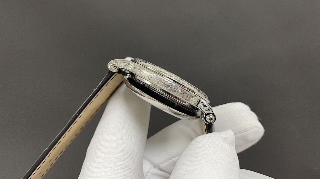 Wristwatch side view with crown and polished silver case on leather strap