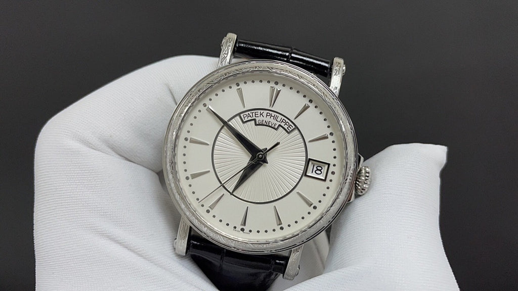 Wristwatch with silver case, white dial, black leather strap and date window