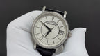 Wristwatch with silver case, white dial, black leather strap and date window