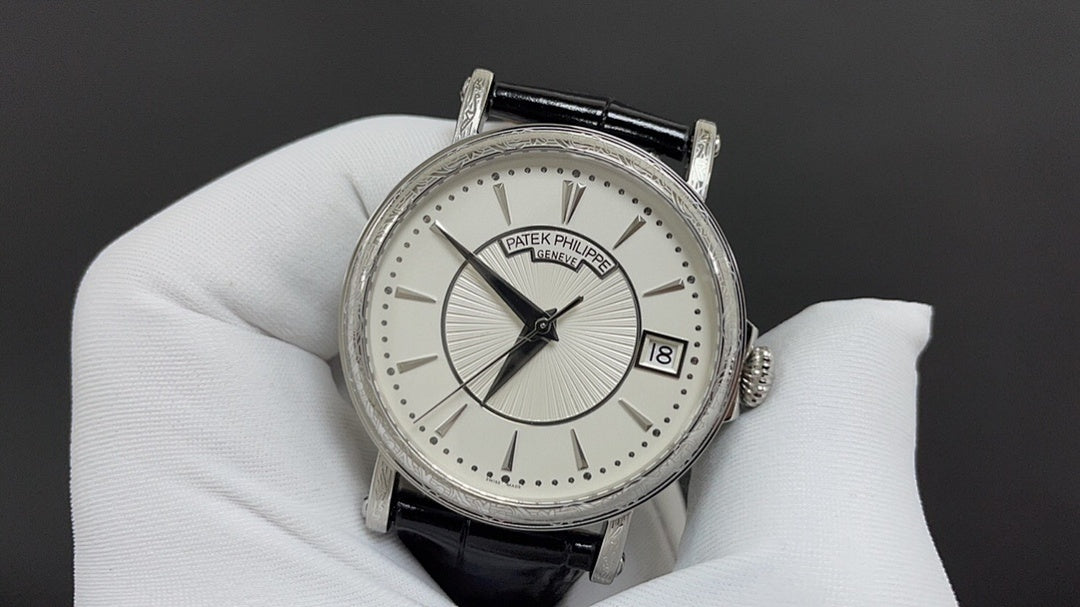 Wristwatch with silver case, white dial, black leather strap and date window