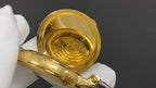 Patek Philippe watch movement close-up with gold-tone back and glass cover