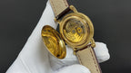 Patek Philippe wristwatch with open case back, gold-tone parts and brown leather strap