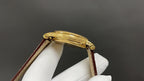 Patek Philippe wristwatch with gold-tone case and brown leather strap, angled profile