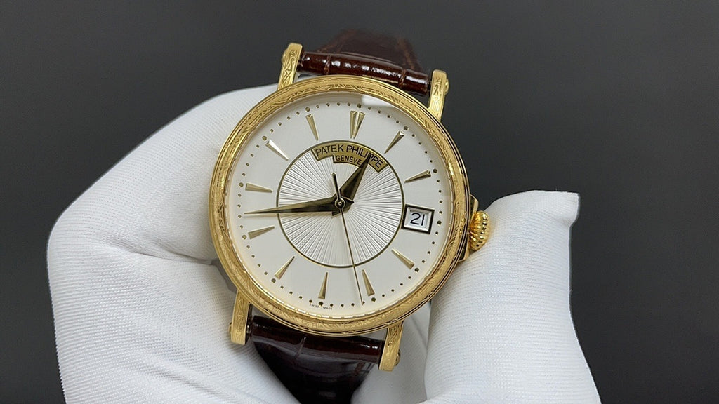 Patek Philippe wristwatch with white dial, black hands, and gold-tone case