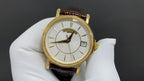 Patek Philippe wristwatch with white dial, black hands, and gold-tone case