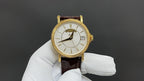 Patek Philippe wristwatch with white dial, gold-tone case, brown leather strap