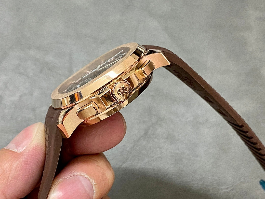 Gold-toned Patek Philippe watch case with crown and brown leather strap