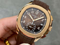 Patek Philippe wristwatch with brown leather strap and gold-toned case, dark dial