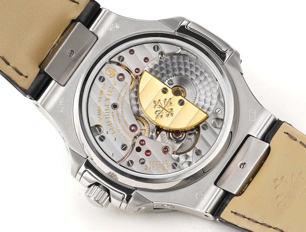 Patek Philippe Nautilus watch movement detail with gold-toned balance and brown leather strap