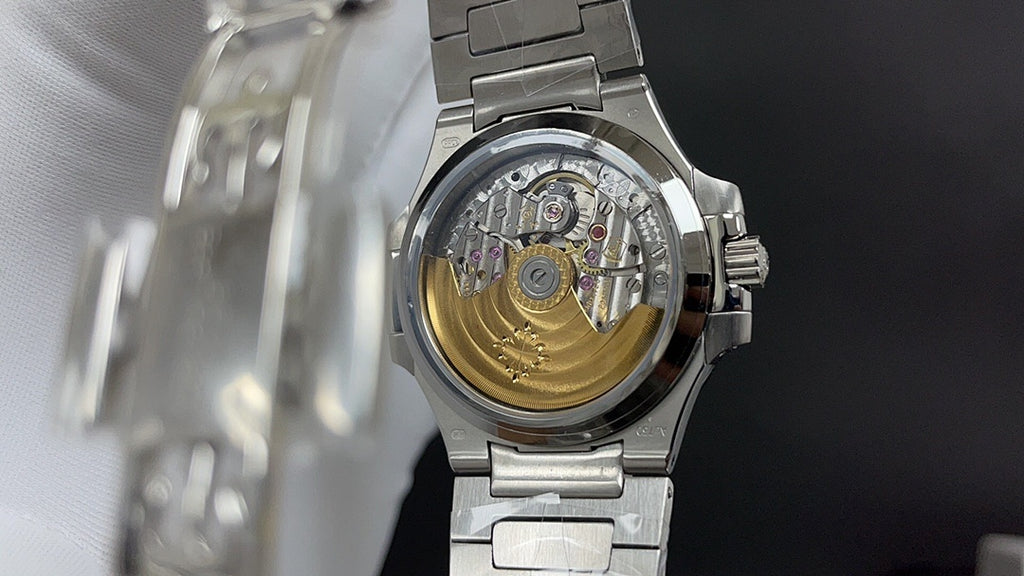 Patek Philippe wristwatch case back with visible mechanical movement, steel bracelet