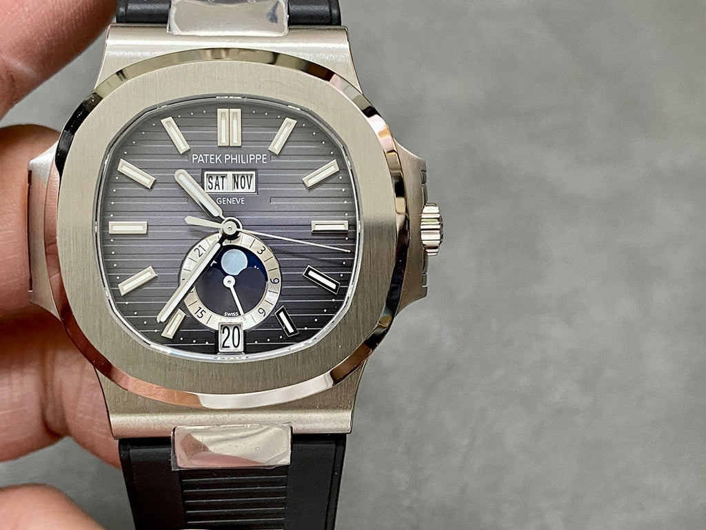 Patek Philippe wristwatch front view with silver bezel, black dial, and rubber strap