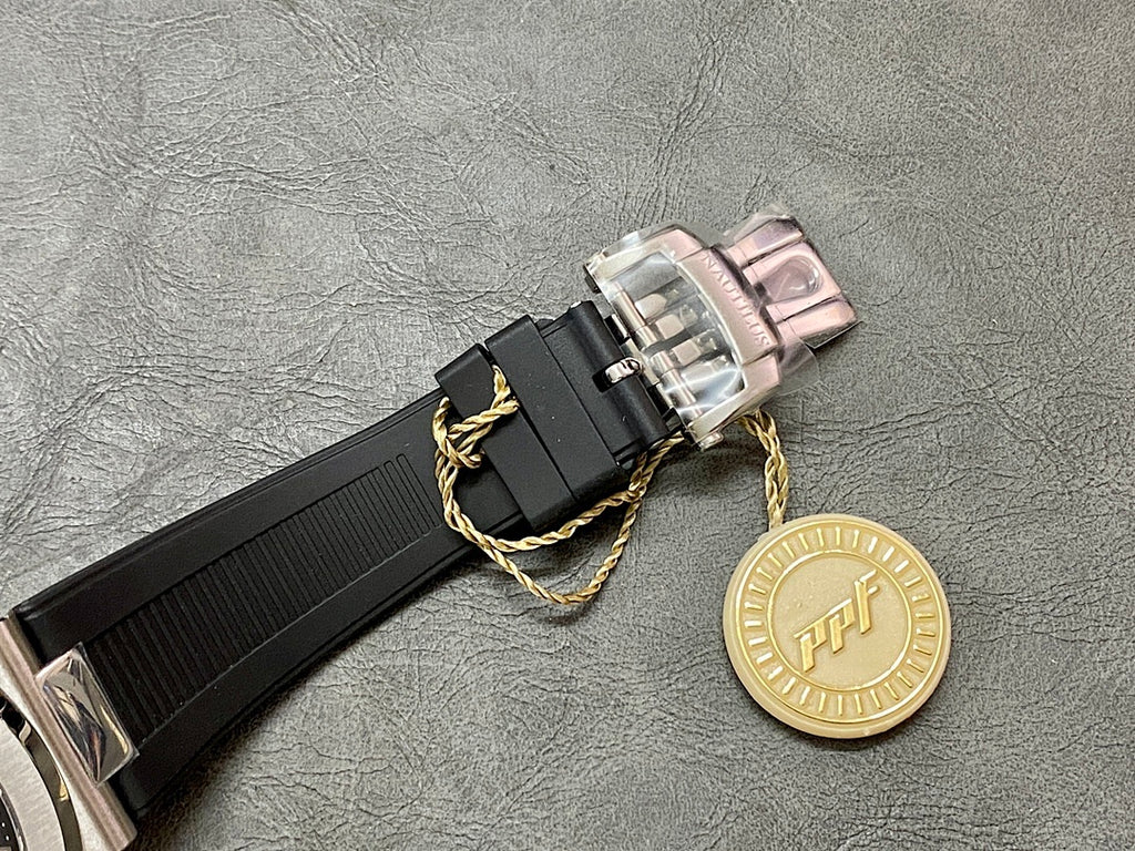 Black rubber watch strap with silver buckle and gold decorative charm