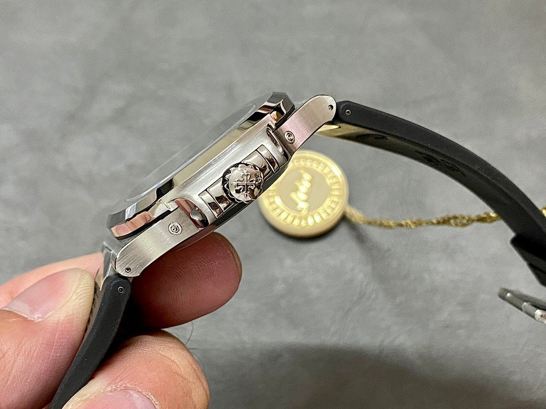 Patek Philippe watch clasp and crown on black rubber strap with metal links