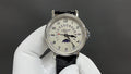 Patek Philippe wristwatch with black leather strap and silver dial, subdials visible