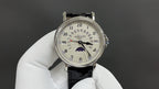 Patek Philippe wristwatch with black leather strap and silver face, subdials on dial