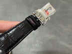 Black leather watch strap with silver buckle clasp and metal strap end