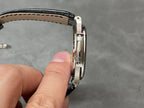 Patek Philippe watch side view with brushed metal links and black leather strap
