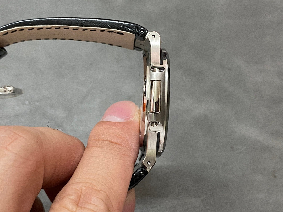 Patek Philippe watch side view with brushed metal links and black leather strap