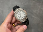 Patek Philippe watch with silver case, white dial, and black leather strap