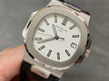 Patek Philippe watch with silver case, white dial, and black leather strap