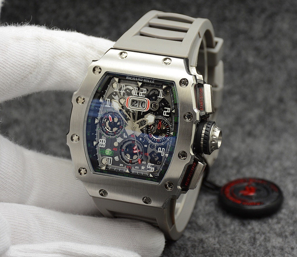 Richard Mille watch with silver case, blue dial, and light gray rubber strap