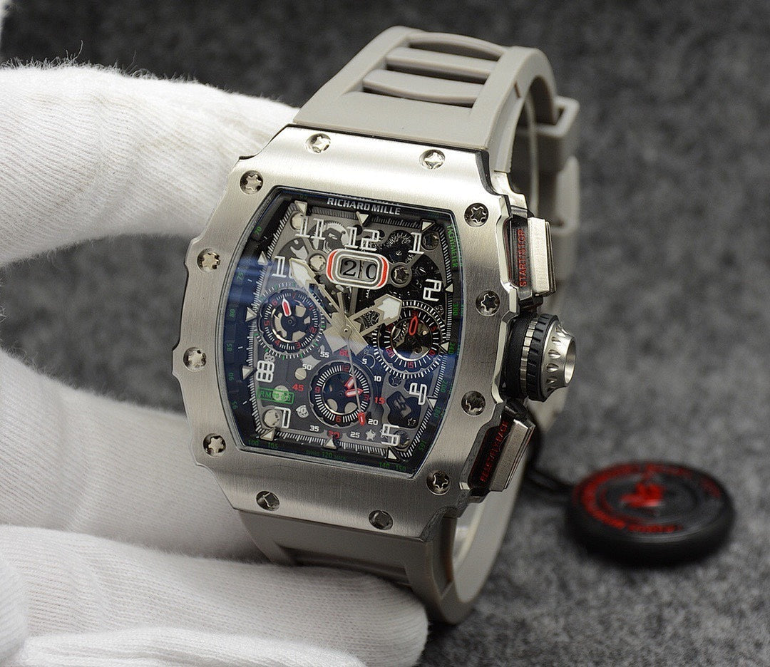 Richard Mille watch with silver case, blue dial, and light gray rubber strap